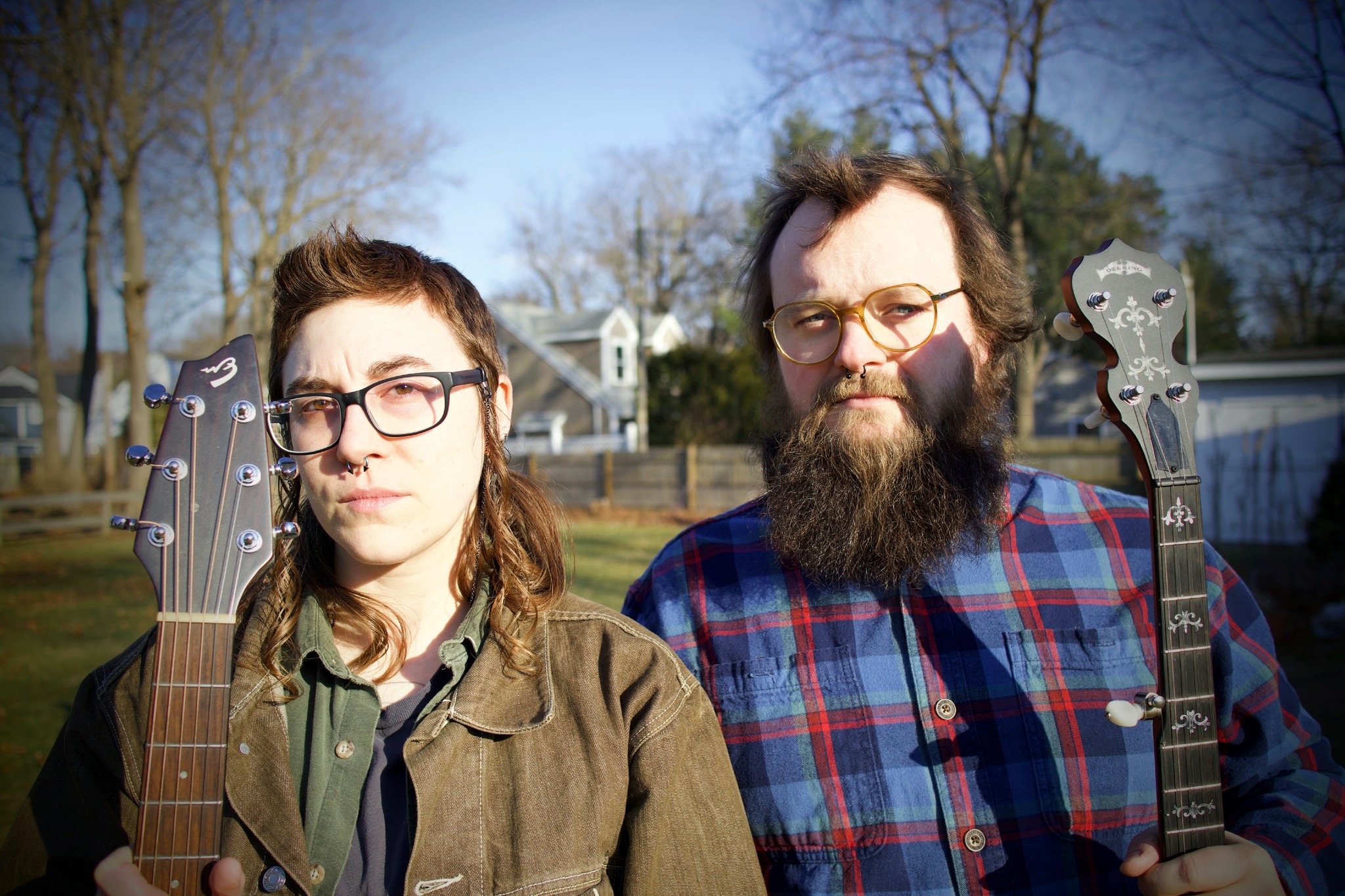 Two Musicians in Fall Clothing holding their respective instruments.